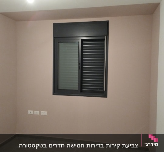 קיר צבוע בצבע ורוד עם חלון שחור